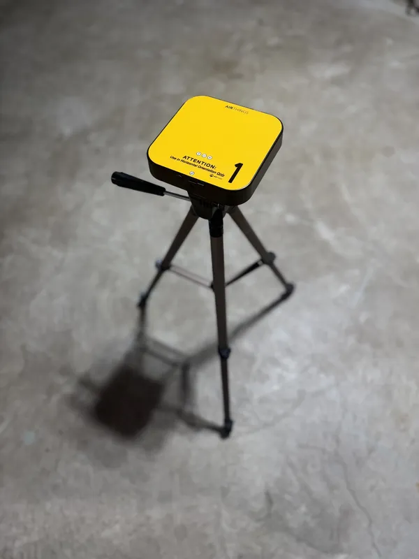 Continuous radon monitor set up on a tripod in a basement during a radon test