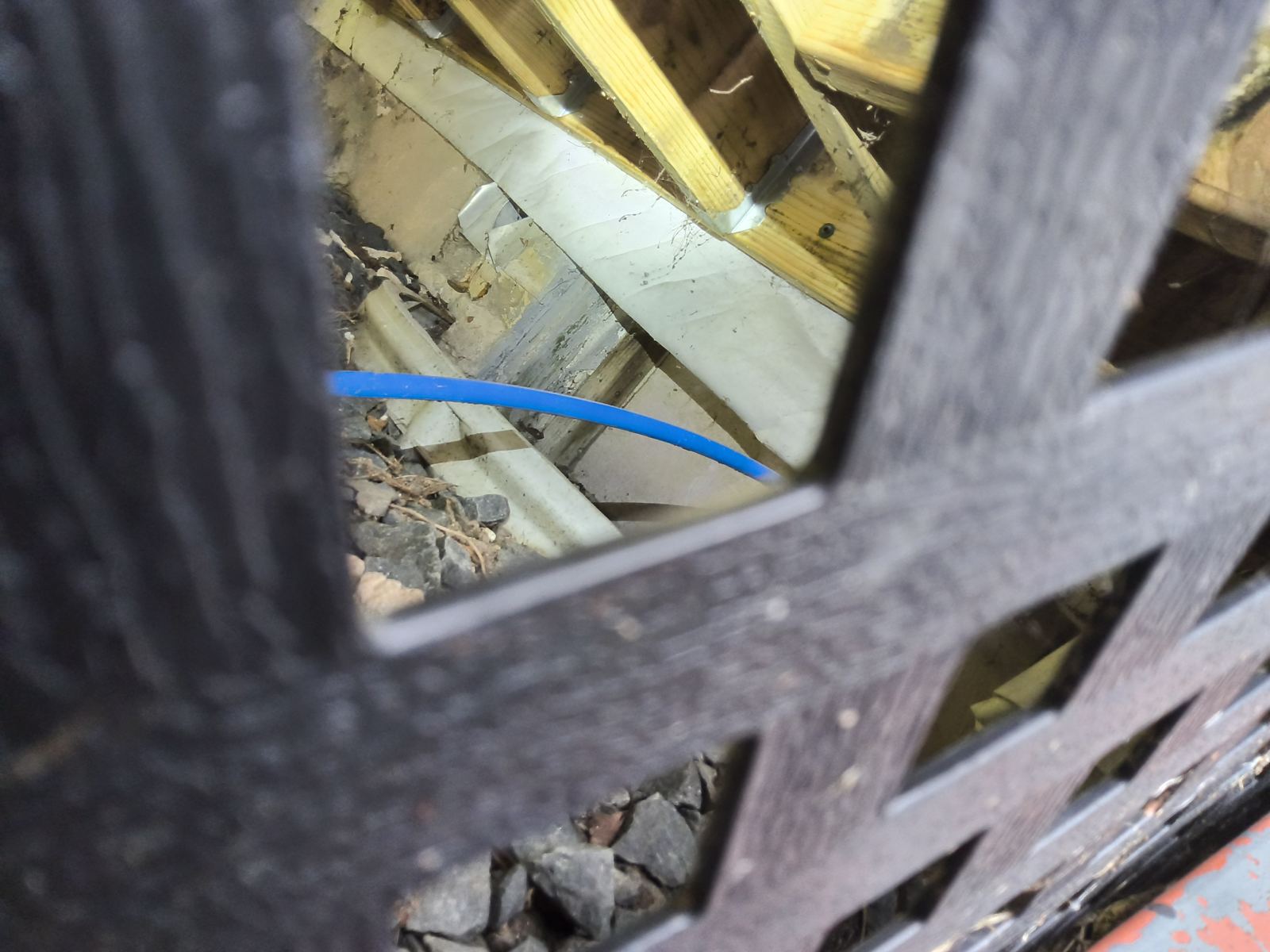 Wood lattice and framing under a deck inspected for wood-to-soil contact and insect activity in Wisconsin