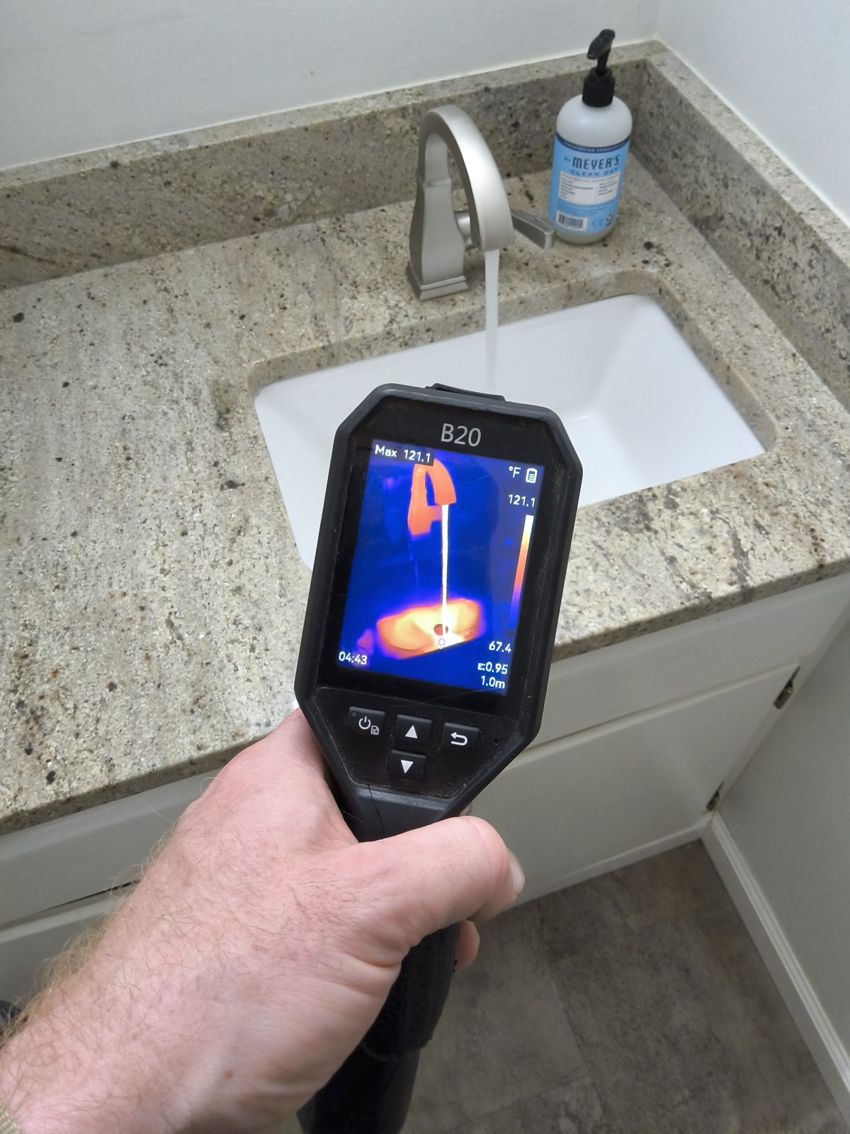 Thermal imaging camera scanning a bathroom vanity and sink for hidden moisture during a Madison-area home inspection